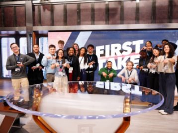 Group of UM students posing in a group in front of the ESPN studio's First Take sign